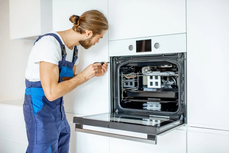Workman installing kitchen oven
