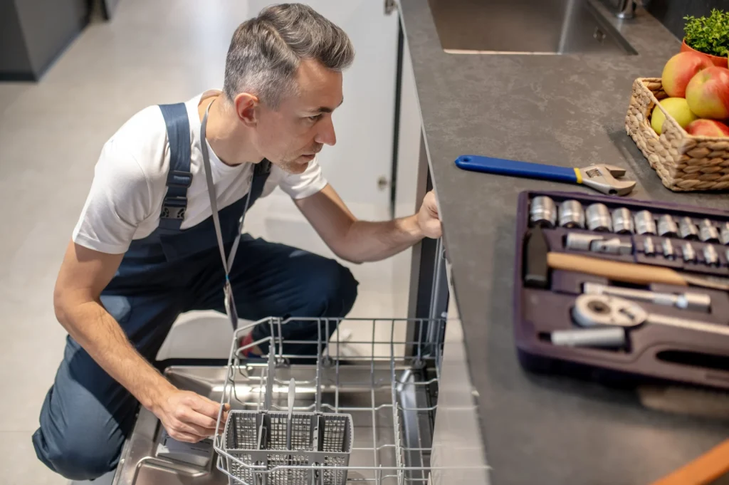 An engineer looking into a dishwasher to troubleshoot