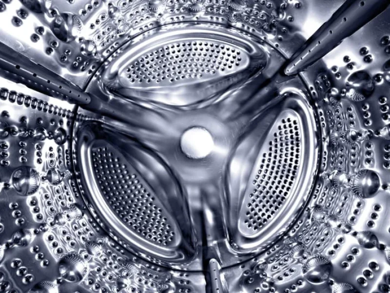 Inside of a shine steel drum of the washing or dryer machine. Laundry day. Daily household chores. Domestic and household appliance. Home innovation.